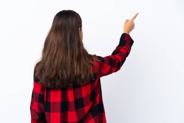 İzole edilmiş beyaz arka planda genç Kolombiyalı kız işaret parmağıyla işaret ediyor.