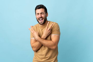 Sakallı, sakallı, sakallı genç adam. Gülümsüyor ve zafer işareti gösteriyor.