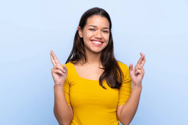 Junge Kolumbianerin Vor Isoliertem Blauen Hintergrund Mit Daumendrücken — Stockfoto