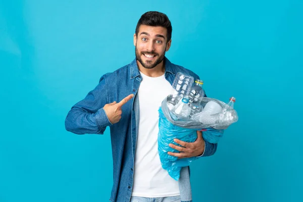 Młody Biały Mężczyzna Trzymając Worek Pełen Plastikowych Butelek Recyklingu Odizolowany — Zdjęcie stockowe