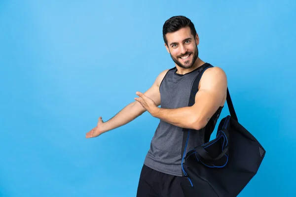 Joven Deportista Con Bolsa Deporte Aislada Sobre Fondo Azul Extendiendo —  Fotos de Stock