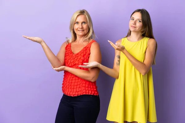 Mom Daughter Isolated Purple Background Extending Hands Side Inviting Come — Stock Photo, Image