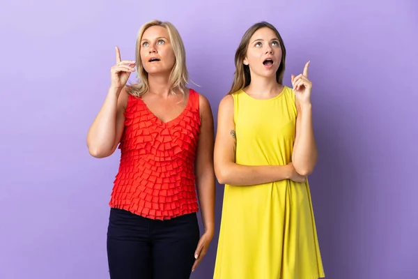 Mãe Filha Isolado Fundo Roxo Pensando Uma Ideia Apontando Dedo — Fotografia de Stock