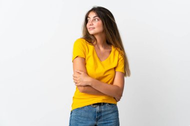 Beyaz arka planda izole edilmiş genç beyaz kadın yan bakıyor ve gülümsüyor.