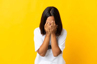 Sarı arka planda izole edilmiş, yorgun ve hasta bir ifadeyle genç gönüllü kadın.