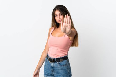 Beyaz arka planda izole edilmiş genç beyaz kadın dur hareketi yapıyor.