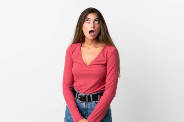 Beyaz arka planda izole edilmiş genç beyaz kadın yukarı bakıyor ve şaşırmış bir ifadeyle