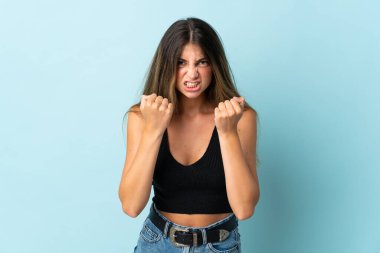 Mavi arka planda izole edilmiş genç beyaz kadın kötü bir durum yüzünden hayal kırıklığına uğradı.