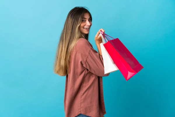 Jonge Kaukasische Vrouw Geïsoleerd Blauwe Achtergrond Met Winkeltassen Glimlachen — Stockfoto