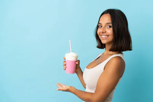 Mujer Joven Con Batido Fresa Aislado Sobre Fondo Azul Extendiendo —  Fotos de Stock