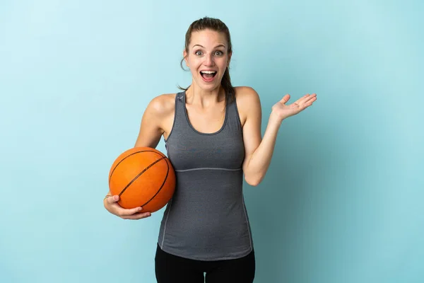 Mladá Žena Hraje Basketbal Izolované Modrém Pozadí Šokovaným Výrazem Obličeje — Stock fotografie