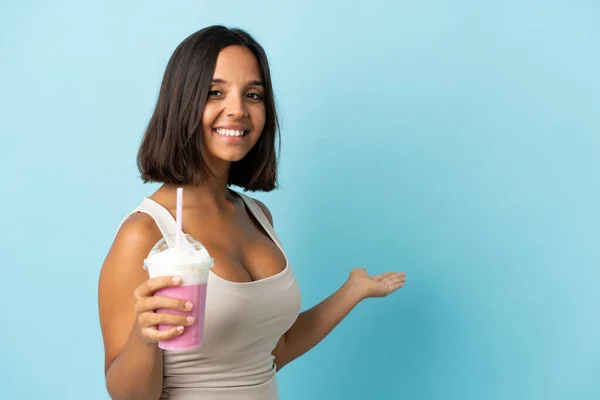 Mujer Joven Con Batido Fresa Aislado Sobre Fondo Azul Extendiendo —  Fotos de Stock