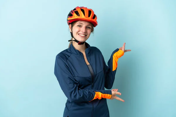Mavi Arka Planda Izole Edilmiş Genç Bisikletçi Kadın Davet Edilmek — Stok fotoğraf