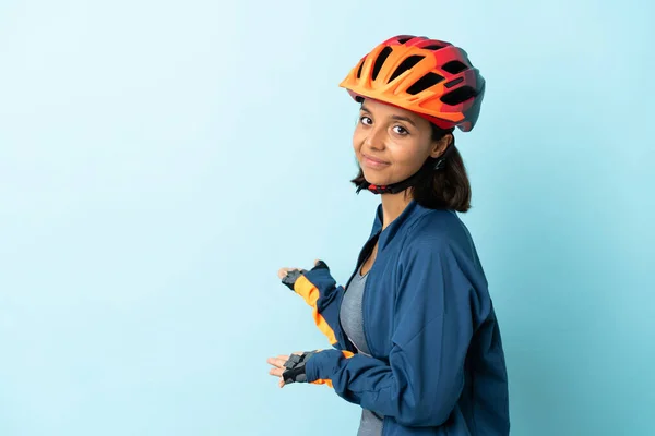 Jonge Fietser Vrouw Geïsoleerd Blauwe Achtergrond Reikende Handen Naar Zijkant — Stockfoto