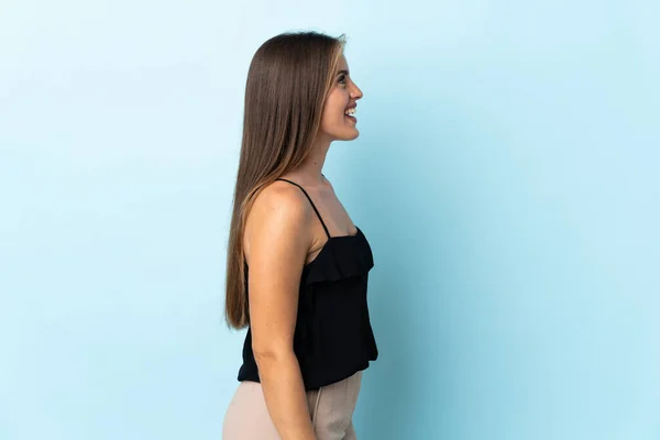 Junge Uruguayische Frau Isoliert Auf Blauem Hintergrund Lacht Seitenlage — Stockfoto