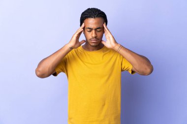 Örgülü genç Afrikalı Amerikalı adam mor arka planda başağrısı ile izole edildi.