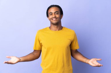 Örgülü genç Afrikalı Amerikalı adam mor arka planda izole edilmiş şüpheleri var.