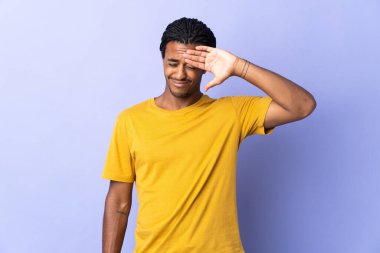 Örgülü genç Afrikalı Amerikalı adam mor arka planda izole edilmiş, yorgun ve hasta bir ifadeyle.