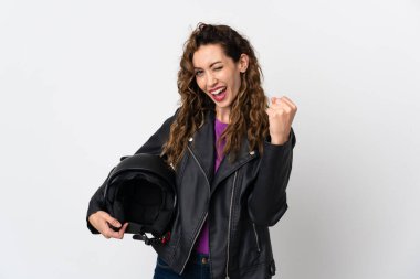 Motosiklet kaskı takan beyaz bir kadın zaferi kutluyor.