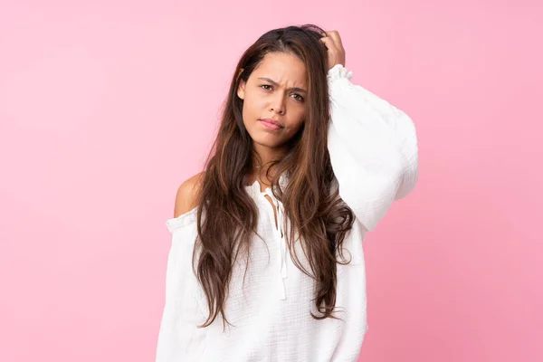 Young Brazilian girl over isolated pink background with an expression of frustration and not understanding