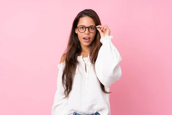 Jovem Brasileira Sobre Fundo Rosa Isolado Com Óculos Surpreso — Fotografia de Stock