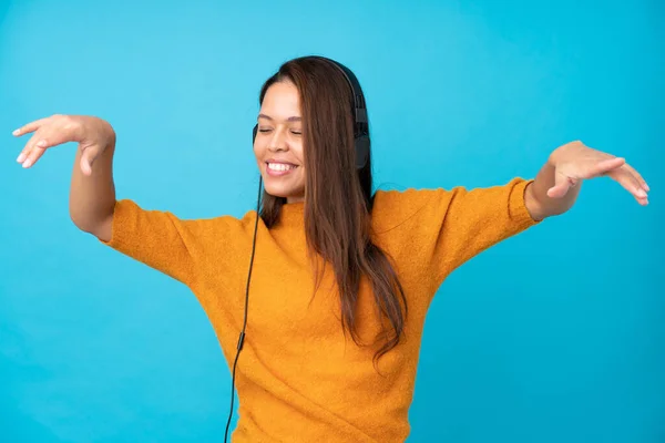 Jonge Vrouw Luisteren Muziek Geïsoleerde Blauwe Muur — Stockfoto