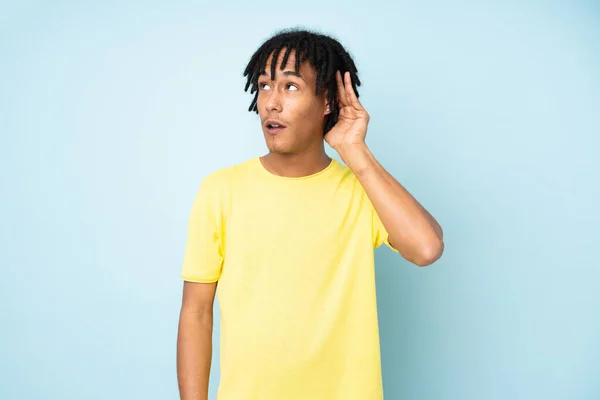 Giovane Uomo Afroamericano Isolato Sfondo Blu Ascoltando Qualcosa Mettendo Mano — Foto Stock