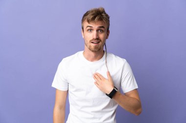 Mor arka planda izole edilmiş yakışıklı sarışın adam kendini işaret ediyor.