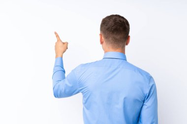 Genç yakışıklı işadamı işaret parmağıyla işaret ediyor.