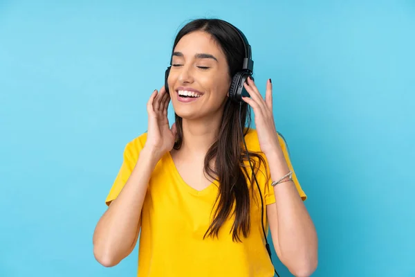 Jovem Morena Sobre Fundo Azul Isolado Ouvindo Música Canto — Fotografia de Stock