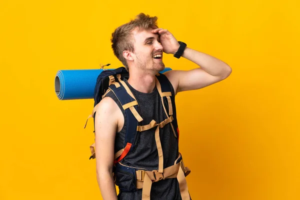 Młody Alpinista Dużym Plecakiem Odizolowany Żółtym Tle Uśmiechający Się Dużo — Zdjęcie stockowe