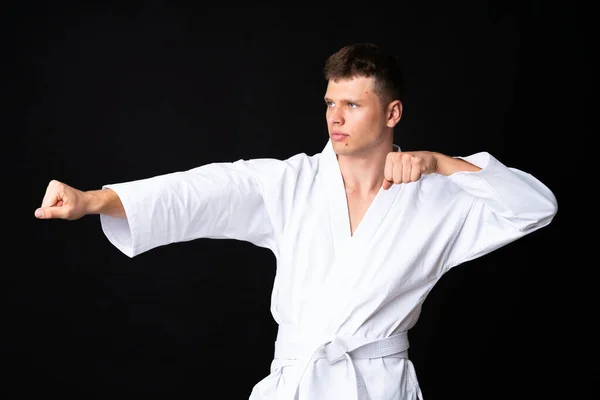 Mladý Muž Dělá Karate Přes Izolované Černé Pozadí — Stock fotografie