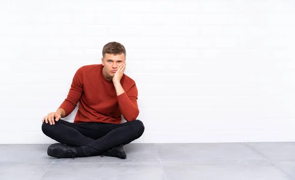 Νεαρός Όμορφος Άντρας Κάθεται Στο Πάτωμα Δυστυχισμένος Και Απογοητευμένος — Φωτογραφία Αρχείου