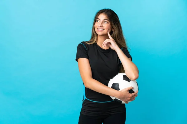 Młoda Piłkarz Kobieta Odizolowany Niebieskim Tle Myśląc Pomysł Podczas Patrząc — Zdjęcie stockowe