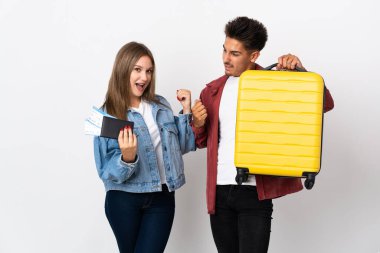 Mavi arka planda bir bavul taşıyan gezgin çift galibiyeti kutluyor.