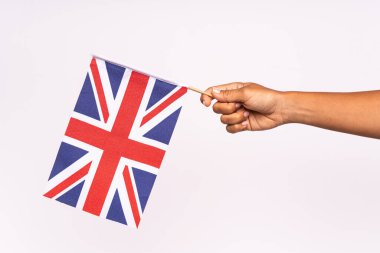 İngiliz bayrağını renk arkaplanına karşı tutarken 