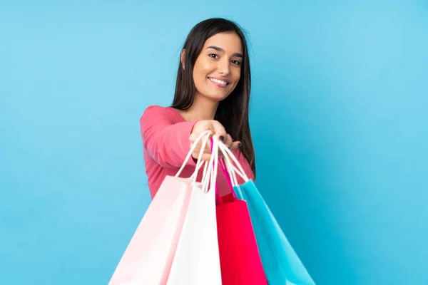 Jong Brunette Vrouw Geïsoleerde Blauwe Achtergrond Holding Shopping Tassen Geven — Stockfoto
