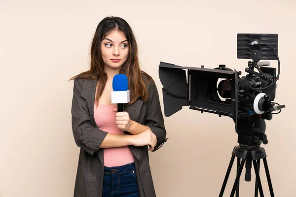 Mulher Repórter Segurando Microfone Relatando Notícias Sobre Fundo Isolado Pensando — Fotografia de Stock