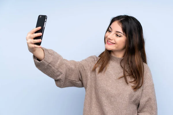 Młoda Brunetka Ubrana Sweter Odizolowanym Niebieskim Tle Robi Selfie — Zdjęcie stockowe