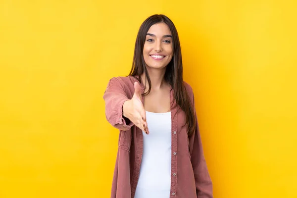 Junge Brünette Frau Vor Isoliertem Gelben Hintergrund Schüttelt Hände Ein — Stockfoto