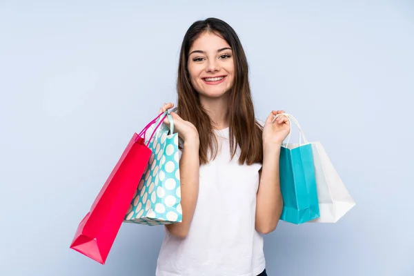 Joven Morena Sobre Fondo Azul Aislado Sosteniendo Bolsas Compras Sonriendo — Foto de Stock