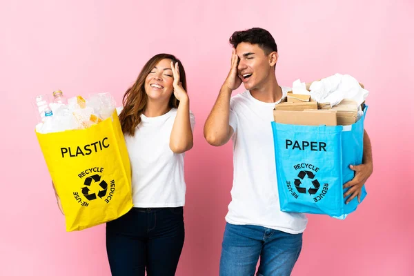 Casal Jovem Segurando Saco Cheio Plástico Papel Isolado Fundo Rosa — Fotografia de Stock