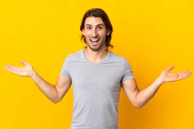 Sarı arka planda izole edilmiş genç ve yakışıklı bir adam.