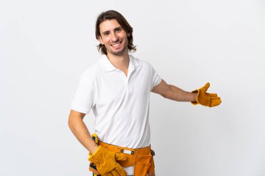 İzole edilmiş arka planda genç elektrikçi. Davet etmek için ellerini yana uzatıyor.