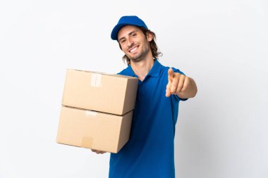 Beyaz arka planda izole edilmiş teslimatçı mutlu bir ifadeyle ön tarafı işaret ediyor.