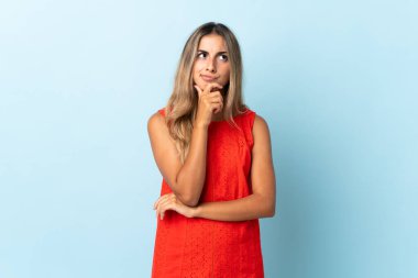 Tecrit edilmiş mavi arka planda genç İspanyol kadın şüpheleri var