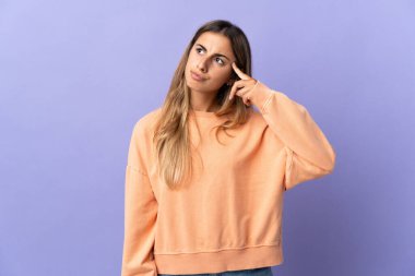 Soyutlanmış mor arka planda genç bir İspanyol kadın deliliğin hareketini yapıyor.