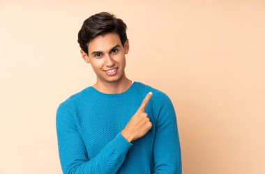 İzole edilmiş arka plandaki adam bir ürünü sunmak için kenarı işaret ediyor.