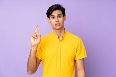 İzole edilmiş mor arka planı olan, şans dileyen ve en iyisini dileyen bir adam.