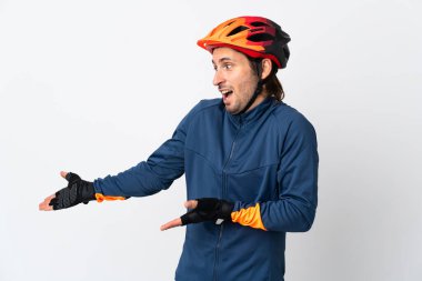 Genç bisikletçi, beyaz arka planda yalıtılmış ve sürpriz bir ifadeyle yan yana bakarken...